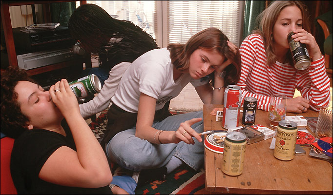 Consumo de alcohol y tabaco entre adolescentes. Grupo de adolescentes consumiendo alcohol y fumando en una reunión informal.