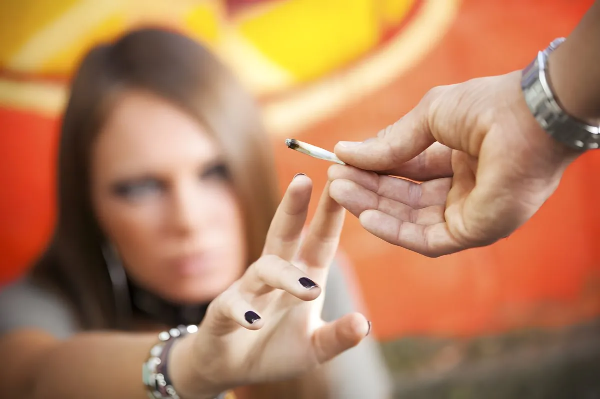Persona joven rechazando un cigarrillo de marihuana, simbolizando la prevención del consumo entre adolescentes.