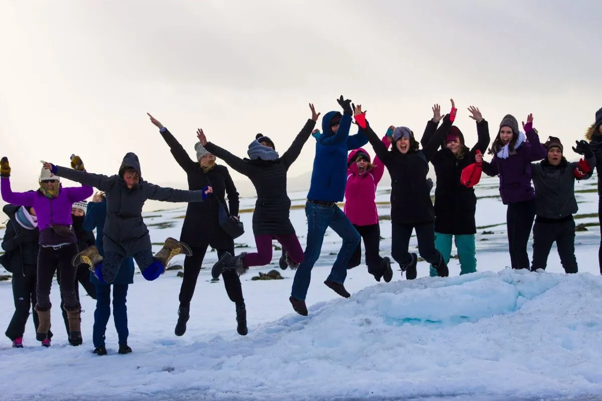 Grupo de jóvenes islandeses saltando sobre la nieve, símbolo del éxito de los programas de prevención de alcohol y tabaco.