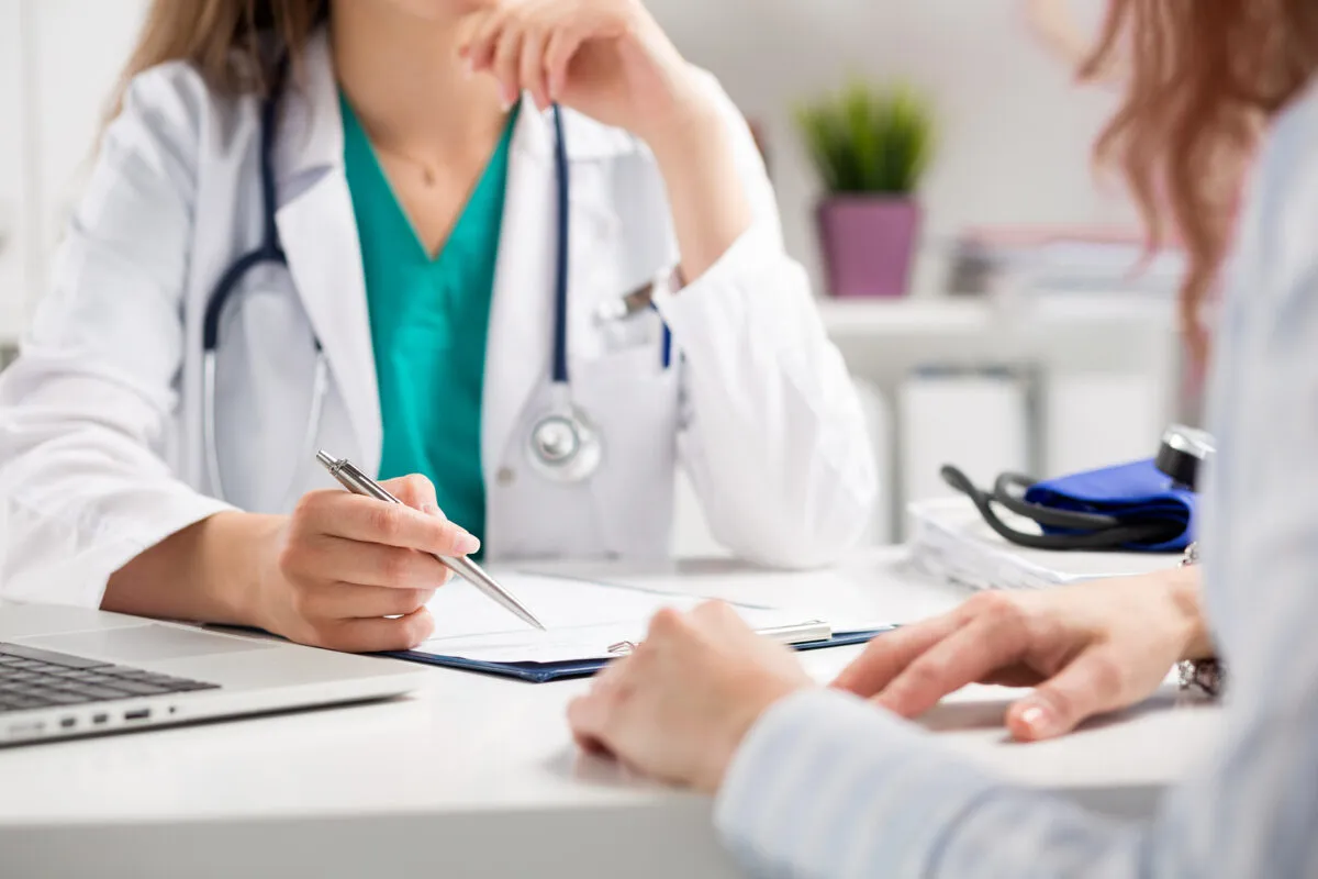 Mujer en una visita al médico conversando con el doctor