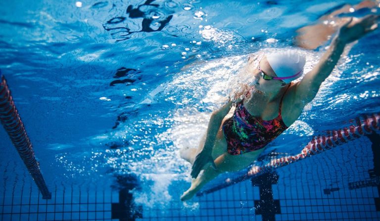 mujer nadando en pileta vista debajo del agua
