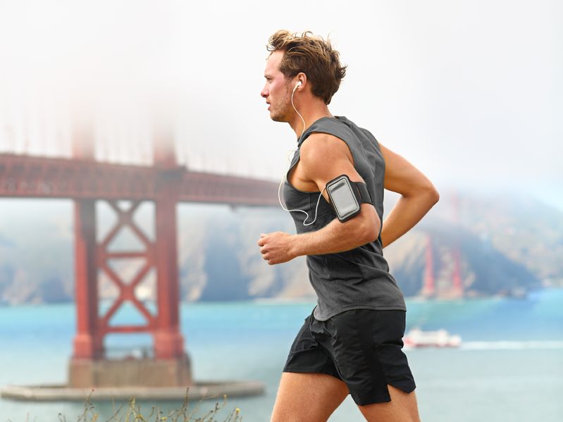 Entrena con energía: música para hacer ejercicio en Spotify 2025. Hombre corriendo frente al Golden Gate Bridge mientras escucha música en Spotify 2025.
