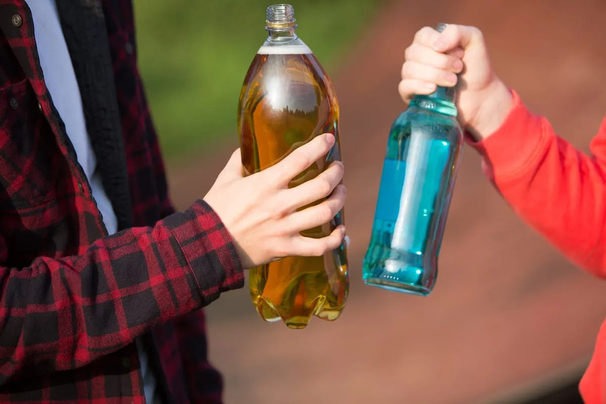 Dos jóvenes comparando tipos de bebidas alcohólicas y cómo cada una afecta las emociones y el estado de ánimo.