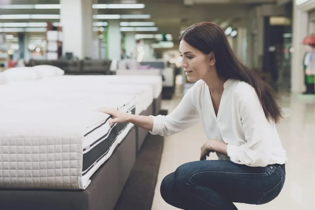 La Importancia de un Buen Colchón en el Tratamiento de la Apnea del Sueño. Mujer eligiendo un colchón firme para mejorar la postura al dormir y ayudar a tratar la apnea del sueño.