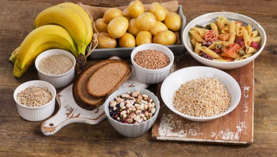 Bodegón de alimentos ricos en carbohidratos como pan, pasta y papas, el tipo de comida que Satial Food ayuda a controlar.