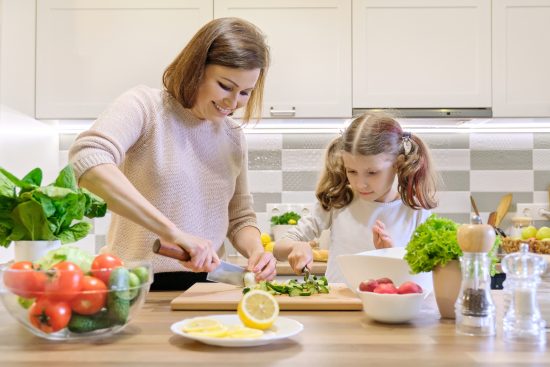 En Feng Shui, la cocina simboliza la abundancia y la salud. madre e hija cocinando