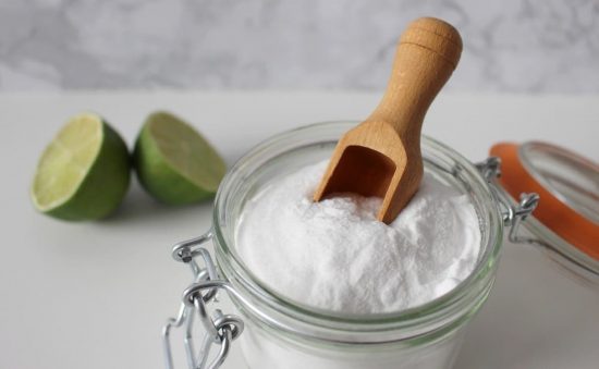 El bicarbonato ayuda a eliminar las células muertas y el exceso de grasa del cuero cabelludo, lo que disminuye la descamación. recipiente de vidrio con bicarbonato y un limón partido