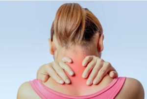 Mujer con dolor en el cuello y la nuca, zona inflamada marcada en rojo por tensión muscular.